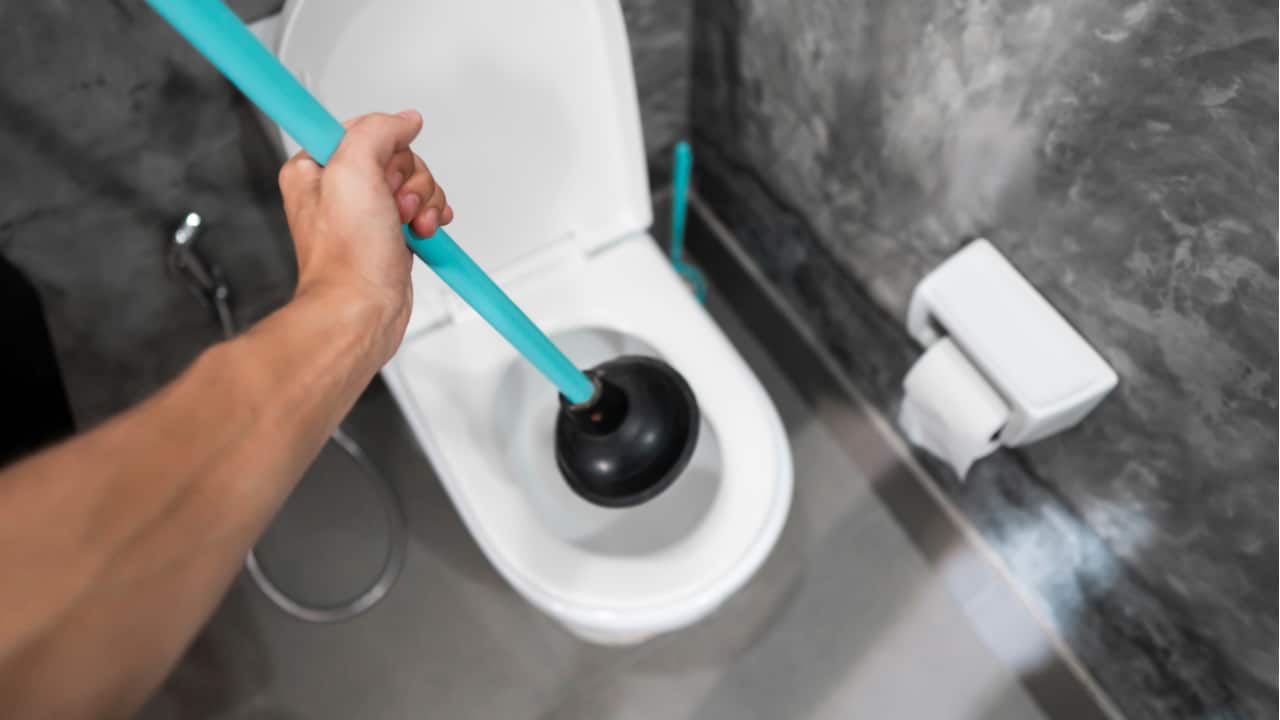Person holds a plunger